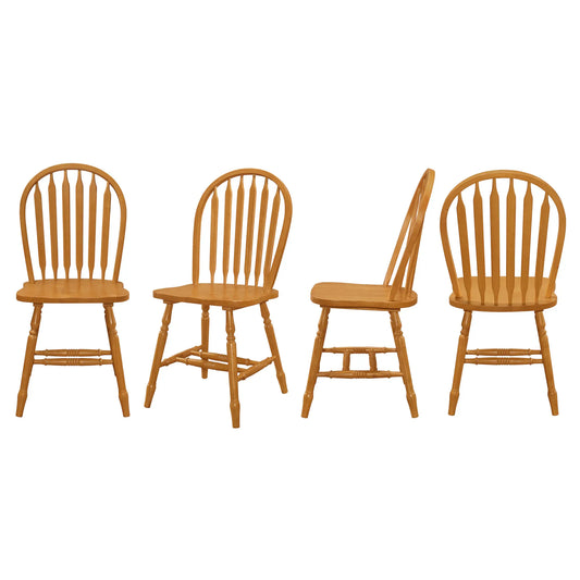 Four wooden chairs with spindle back design on a white background