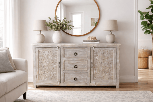 Living room with a wooden sideboard, round mirror, and decorative items.