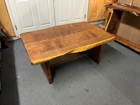 Wooden table with a natural finish on a gray floor.