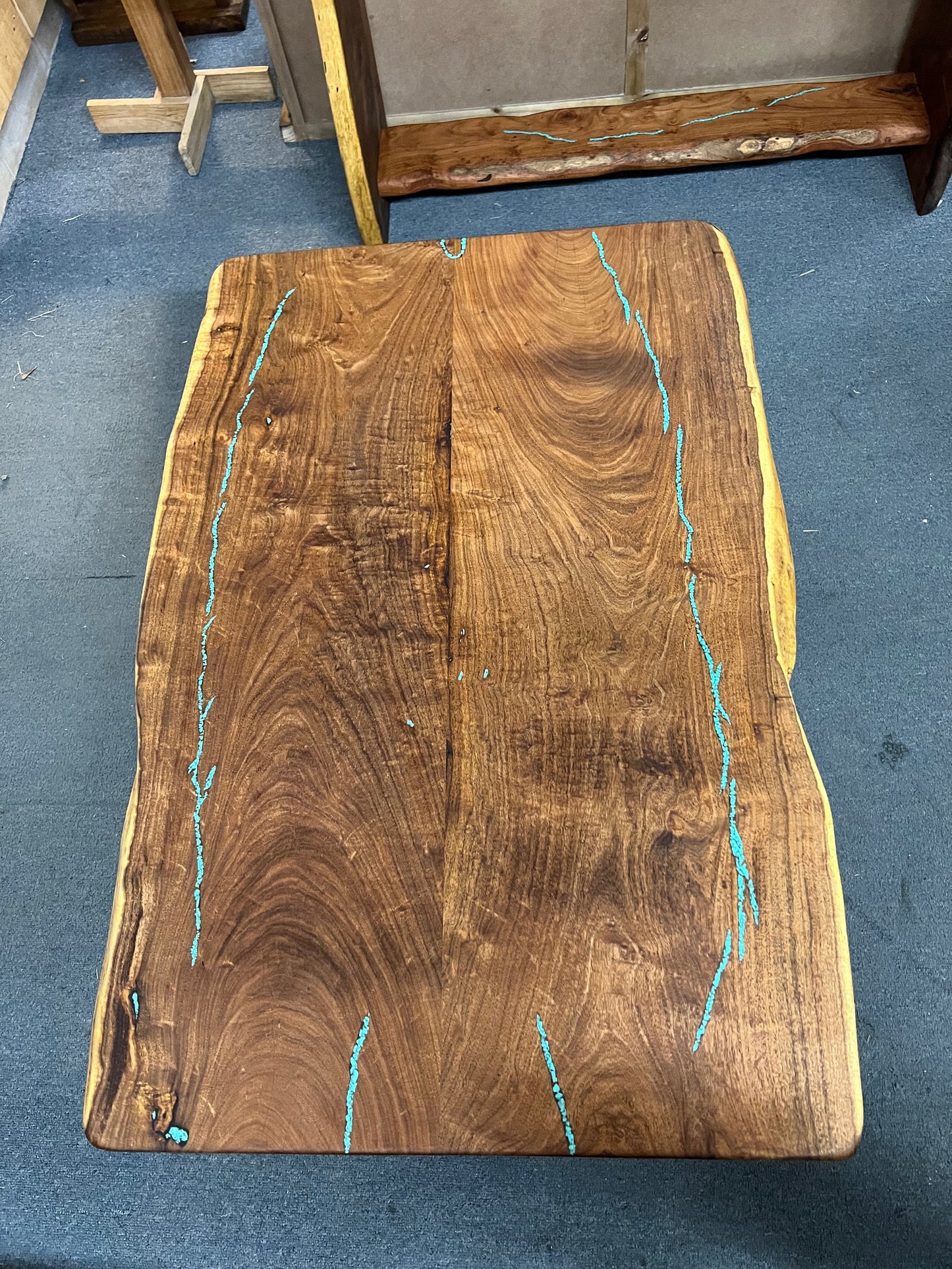Wooden slab with turquoise inlay on a blue carpeted floor