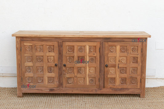 Wooden sideboard with carved patterns on a white wall background