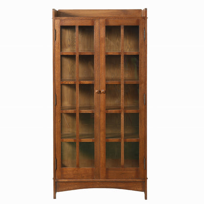 A tall wooden display cabinet with two glass-paneled doors and multiple interior shelves, shown against a plain white background.