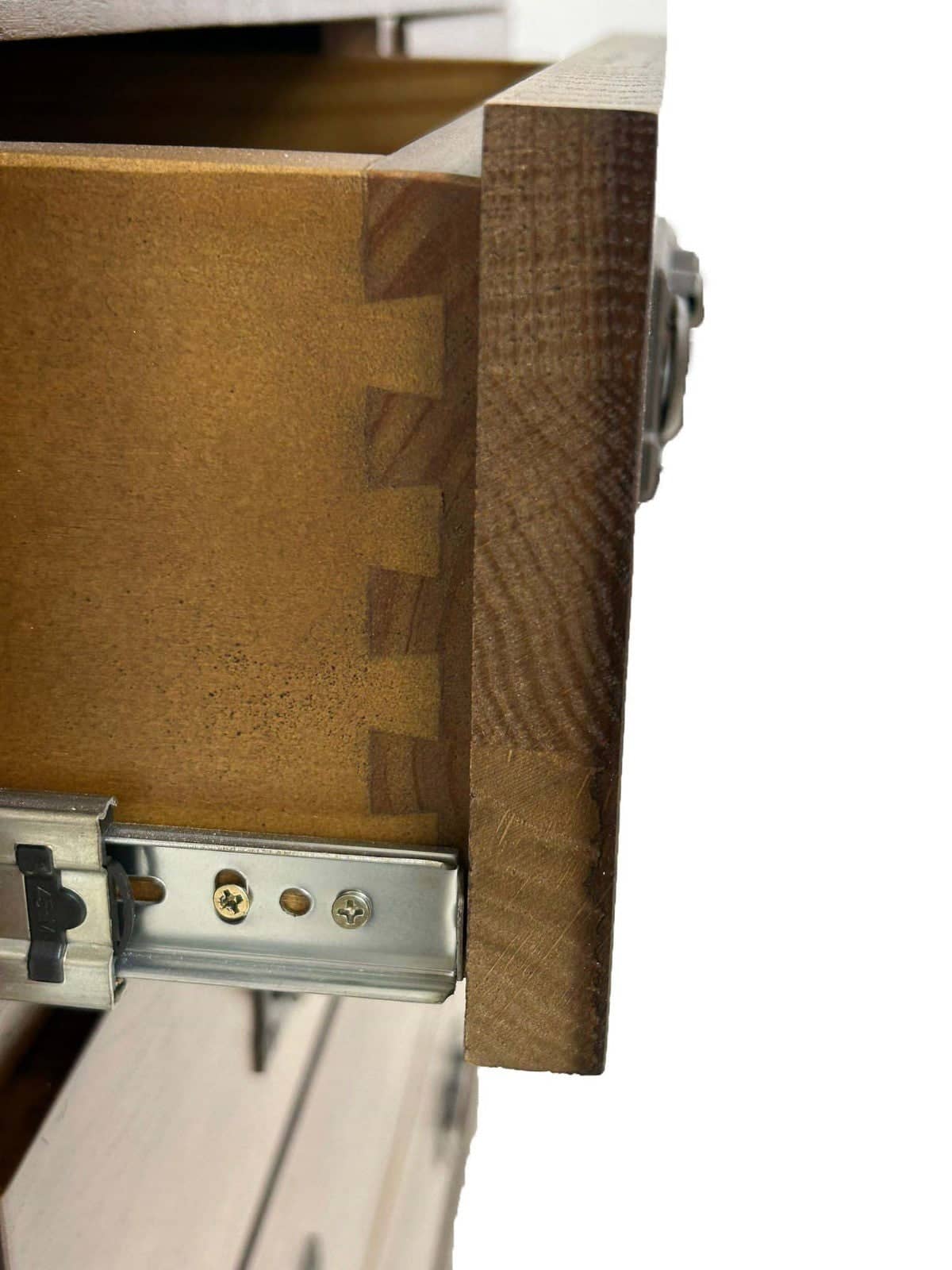 Close-up of a wooden drawer with dovetail joint construction and a metal slide drawer pull mechanism, shown against a white background.