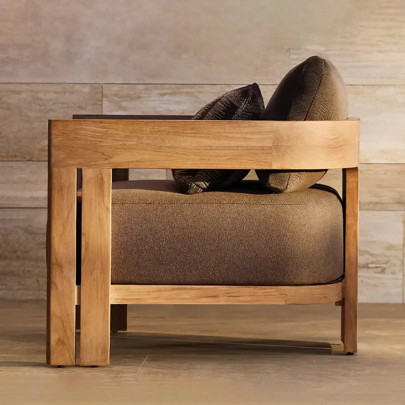 Wooden armchair with brown cushions against a wooden wall.