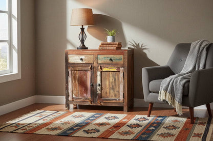Living room with wooden sideboard, gray armchair, and patterned rug.