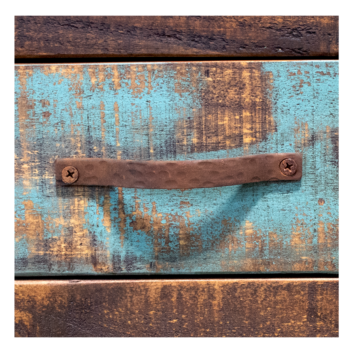 Hardware: Close-up of rusted metal drawer pull against distressed turquoise and brown wood
