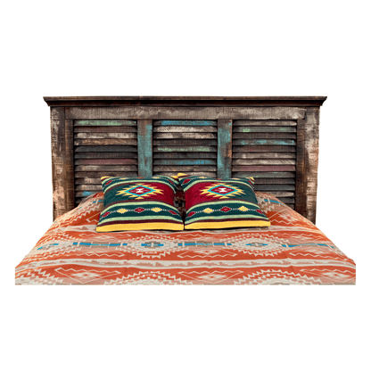 Bed with wooden headboard and patterned bedding on a white background