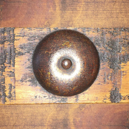 Rust-colored metal object on a wooden surface