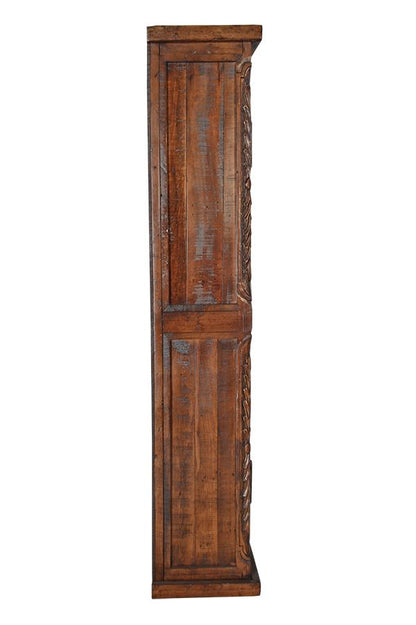 A tall, narrow rustic wooden cabinet or shelf with a distressed brown finish and carved side detailing, shown against a plain white background.