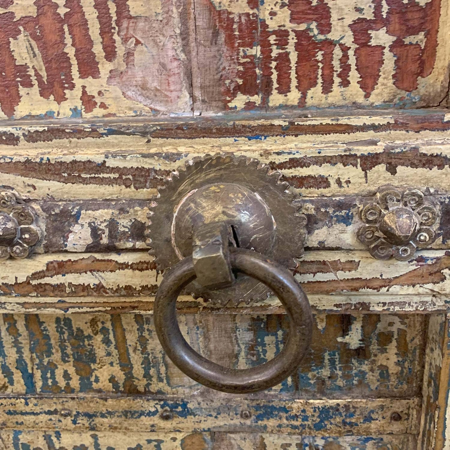 Rustic wooden door with a metal handle and peeling paint