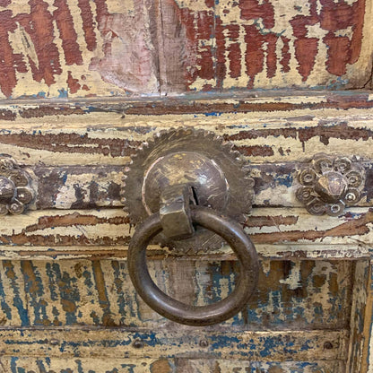 Rustic wooden door with a metal handle and peeling paint