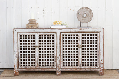 Vintage-style sideboard with lattice doors against a white wall.
