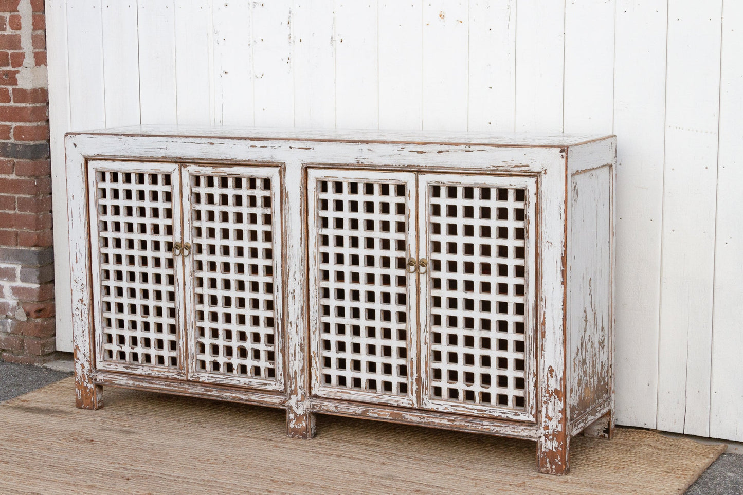 Vintage-style sideboard with lattice doors against a white wall.