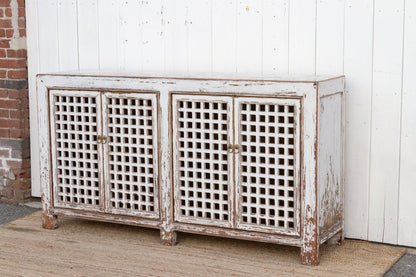 Vintage-style sideboard with lattice doors against a white wall.