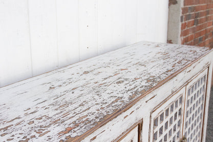 Weathered wooden surface with a white wall and brick wall in the background