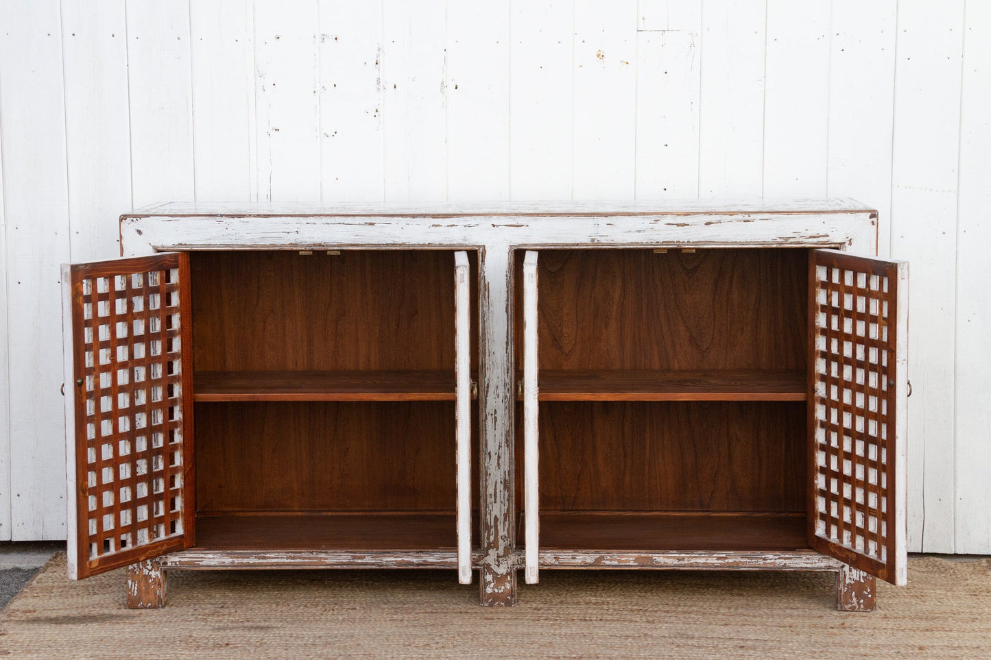 Wooden cabinet with lattice doors against a white wall