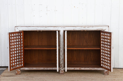 Wooden cabinet with lattice doors against a white wall
