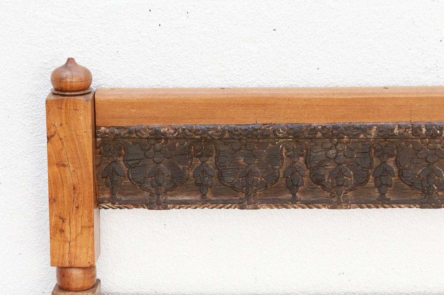 Wooden headboard with decorative carvings on a white background