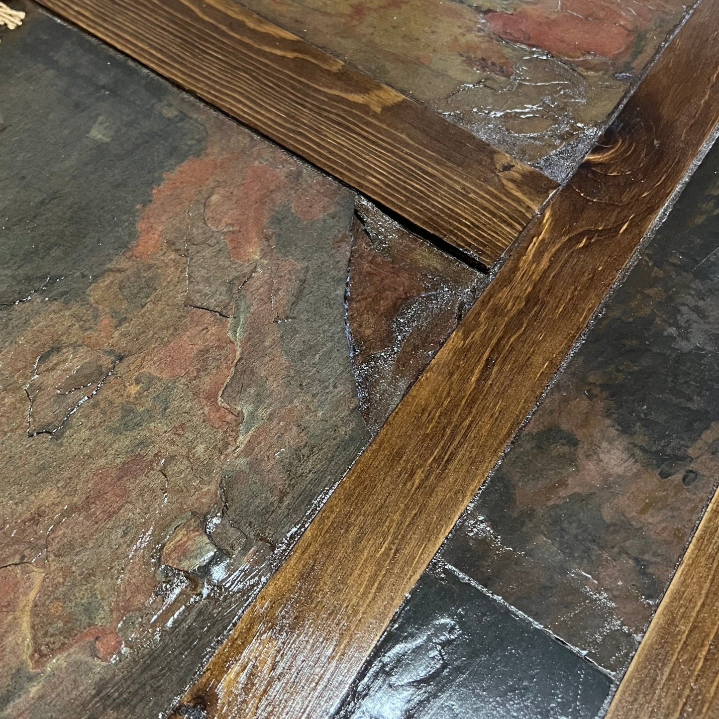 Close-up of stone and wood flooring with a focus on the joint between them.