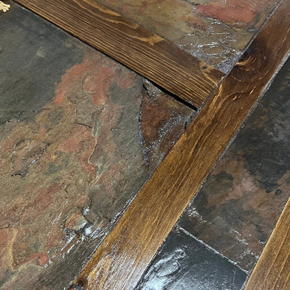 Close-up of stone and wood flooring with a focus on the joint between them.