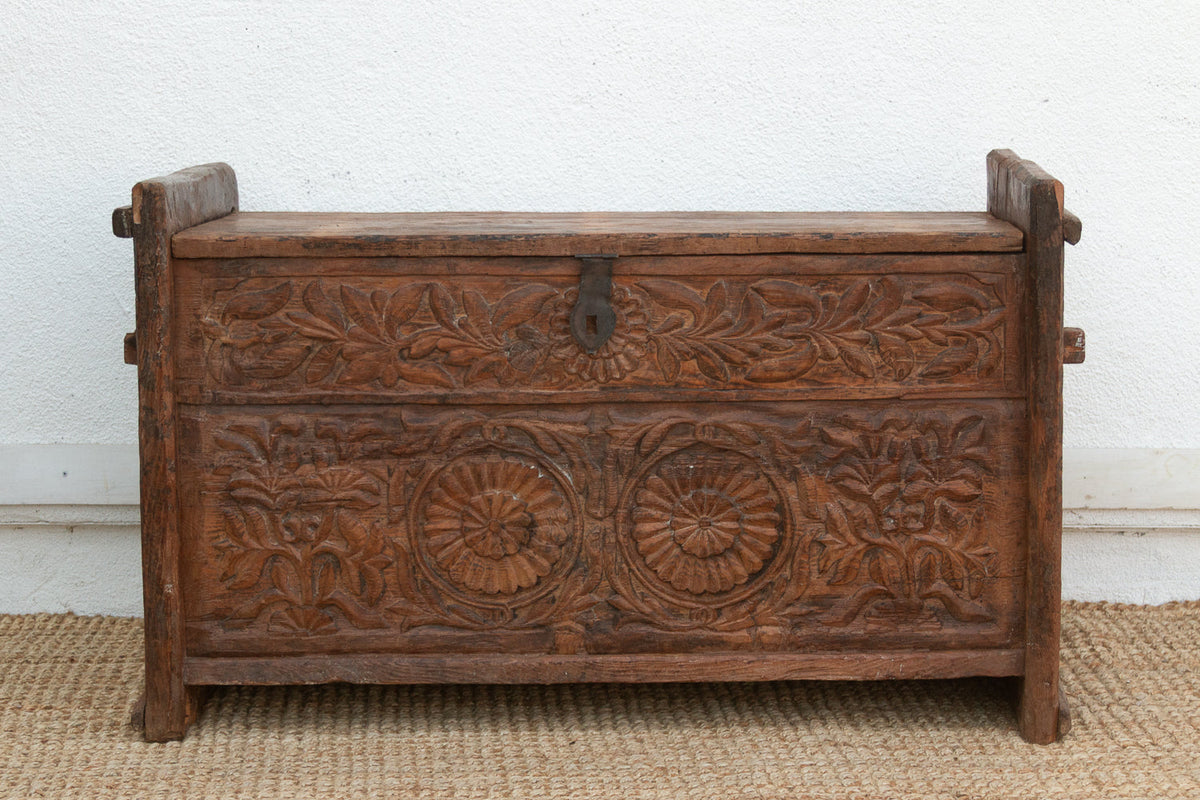 Wooden chest with intricate carvings on a plain background