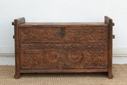 Wooden chest with intricate carvings on a plain background