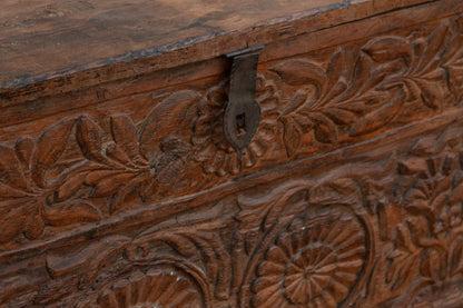 Wooden box with intricate carvings and a metal latch.