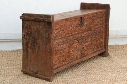 Wooden chest with intricate carvings on a textured surface