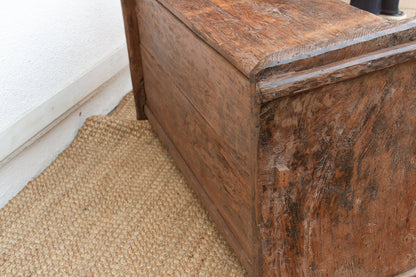 Wooden drawer with a textured brown surface on a beige carpet
