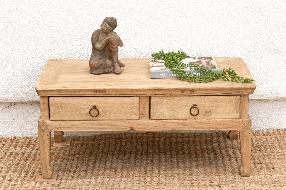 Wooden coffee table with decorative items on a textured surface