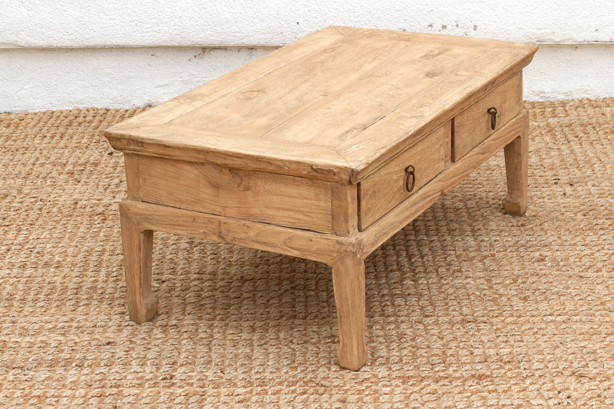 Wooden coffee table with two drawers on a textured rug