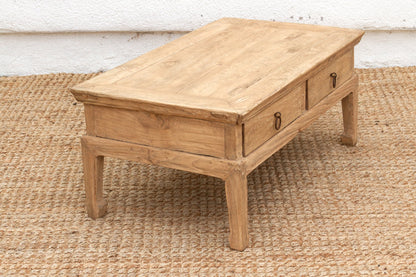 Wooden coffee table with two drawers on a textured rug