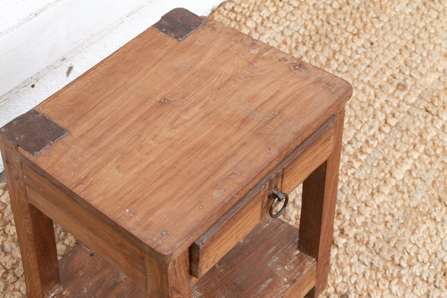 Wooden table with metal brackets on a textured surface