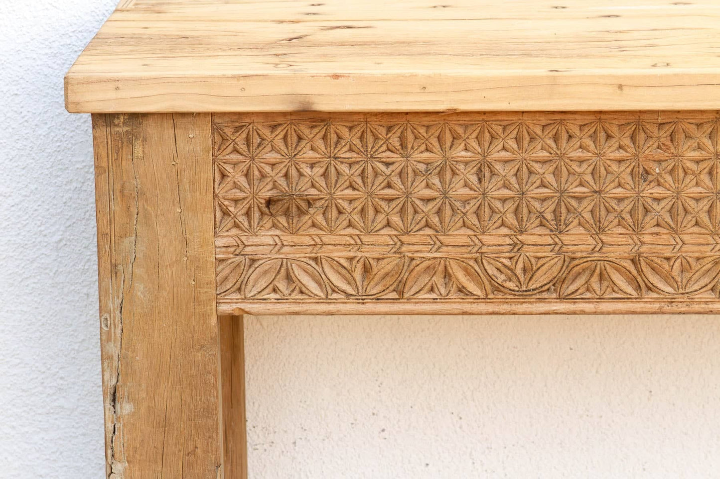 Wooden table with intricate carvings on a white background