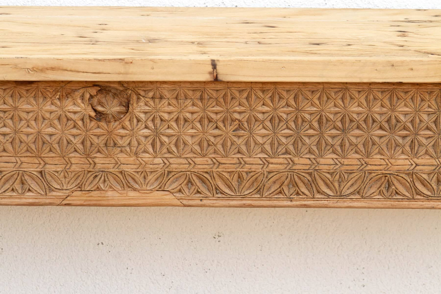 Wooden panel with intricate carvings on a white background