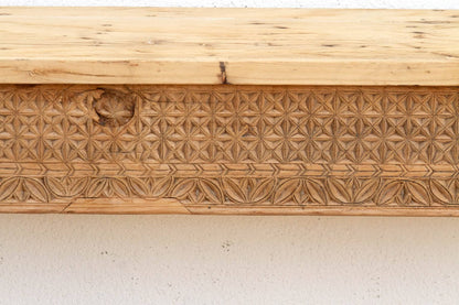 Wooden panel with intricate carvings on a white background