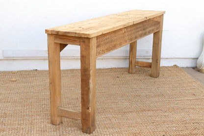 Wooden bench on a textured floor with a white wall background