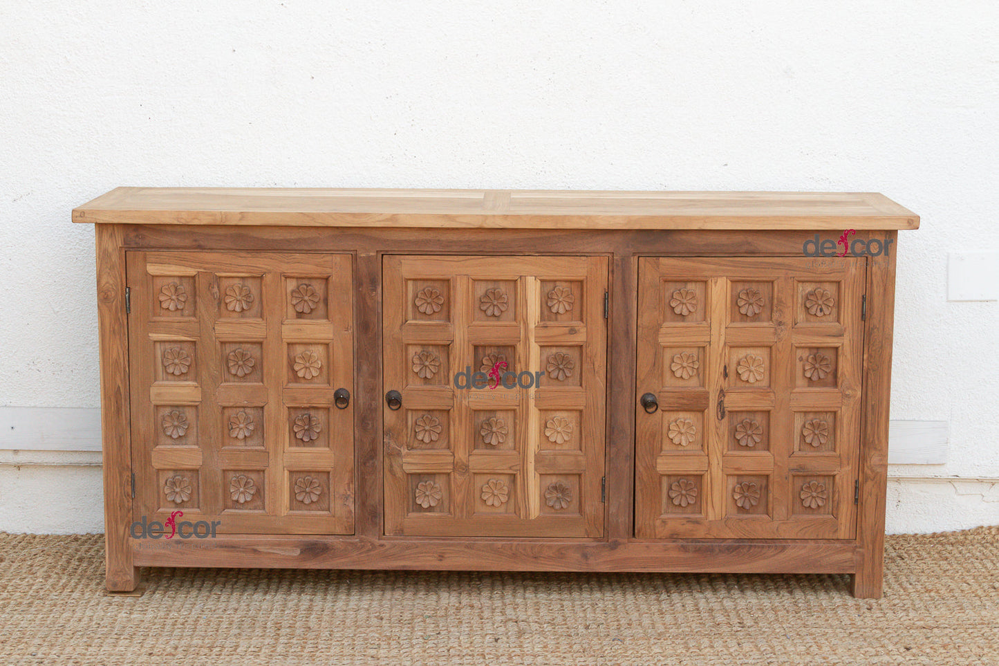 Wooden sideboard with carved patterns on a white wall background