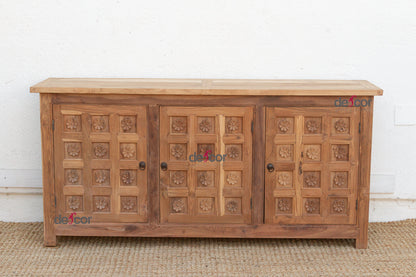 Wooden sideboard with carved patterns on a white wall background