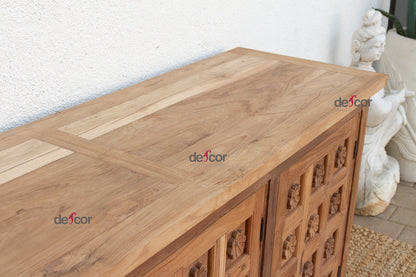 Wooden sideboard with decorative carvings on a white wall background