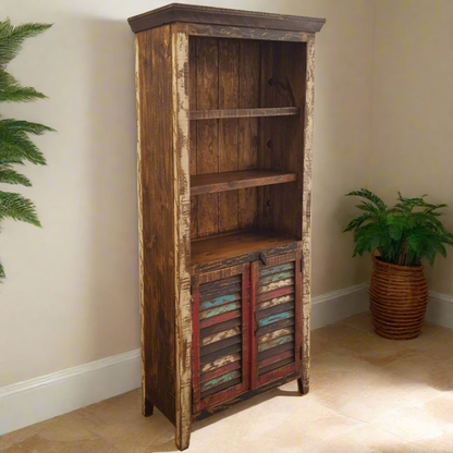 A tall rustic wooden hutch cabinet with a distressed finish, featuring three open shelves on the upper section and two slatted doors with multicolored painted accents on the lower cabinet. The cabinet is photographed in a home interior setting with a potted fern in the background.