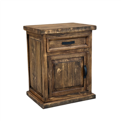 Angled view: Oasis rustic pine nightstand with one drawer, a paneled cabinet door and dark metal hardware in Far West finish