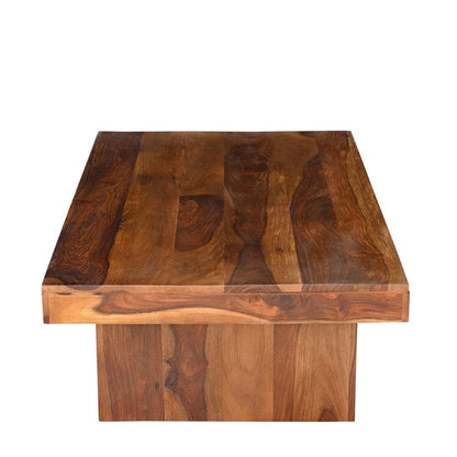A square wooden coffee table with a thick, polished top and a solid pedestal base, crafted from rich brown wood with prominent grain patterns.