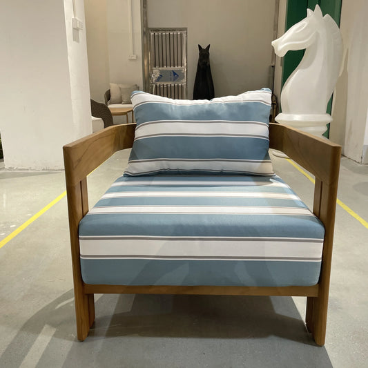 Chair with blue and white striped cushion and pillow in a room setting.