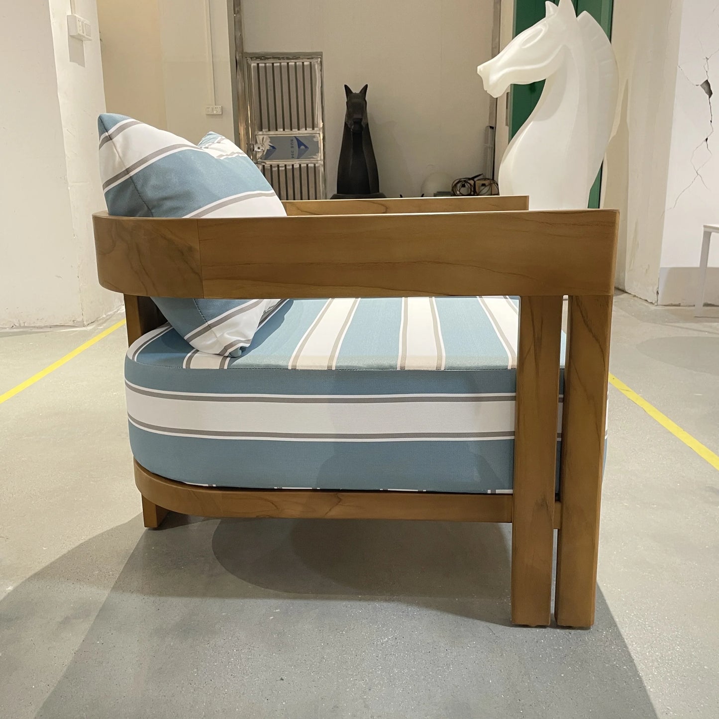 Wooden bed frame with striped mattress and pillows in a room setting.